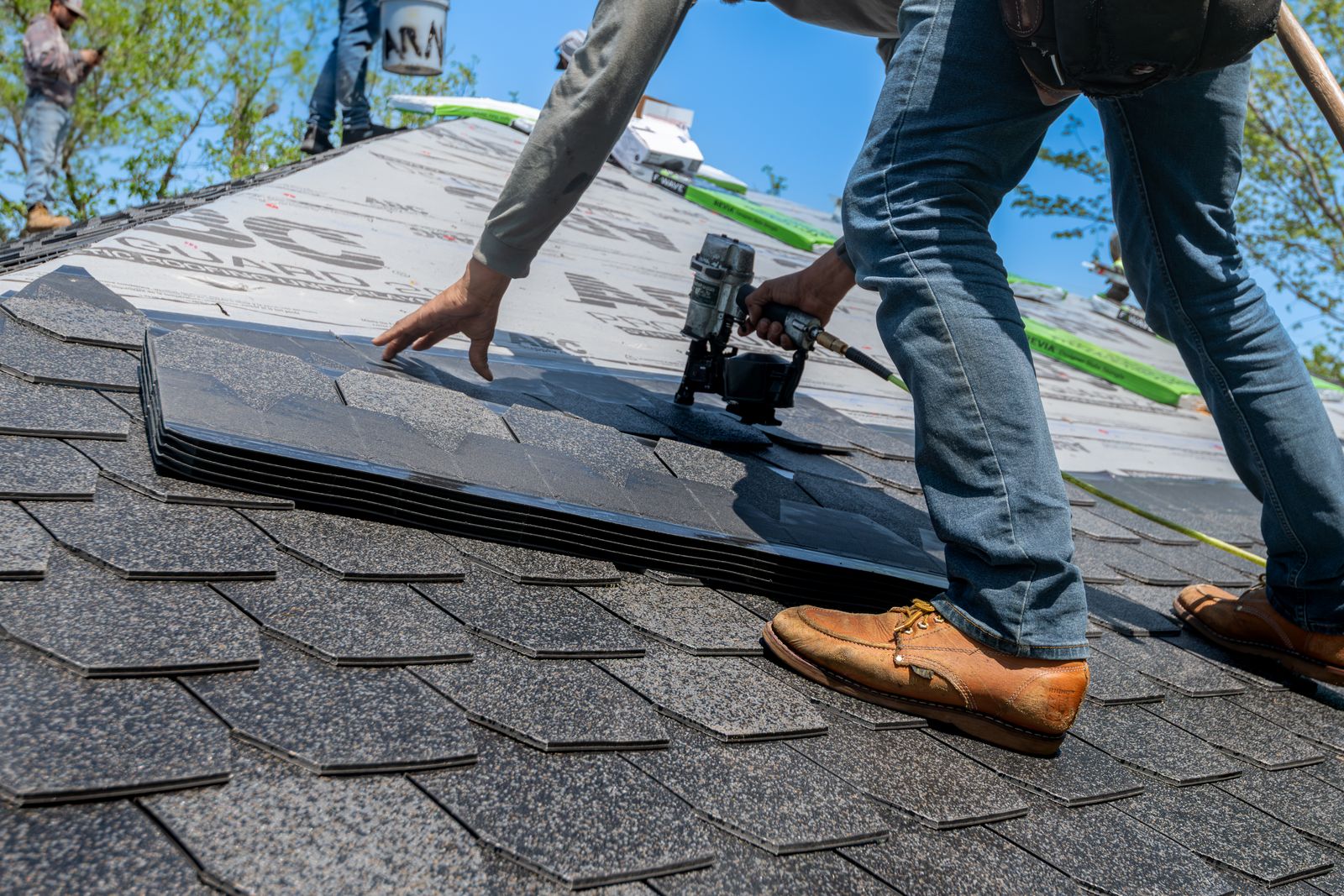 A verified local roofer installing new shingles on a residential roof